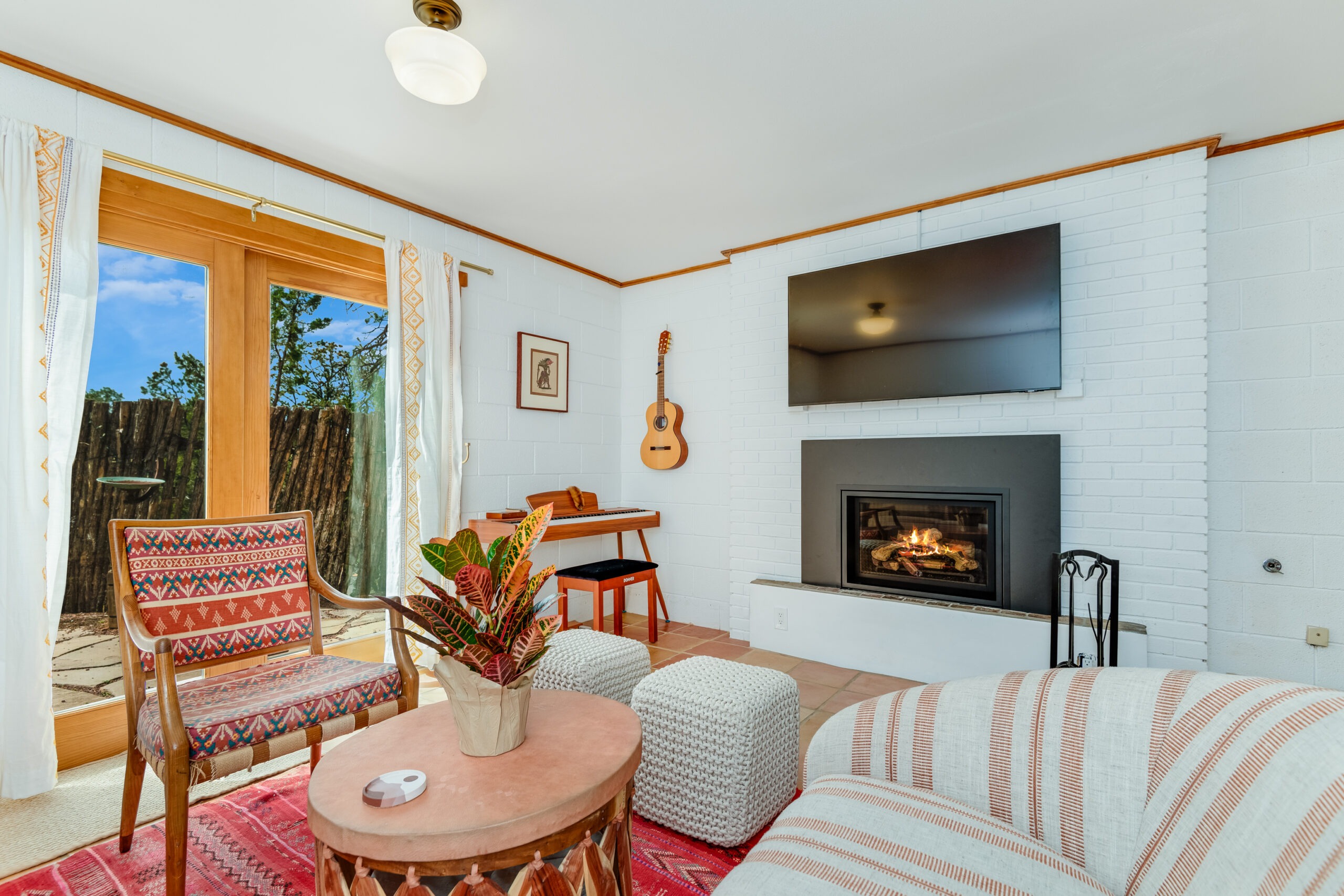 Cozy living room with a white brick wall, wall-mounted TV, and fireplace